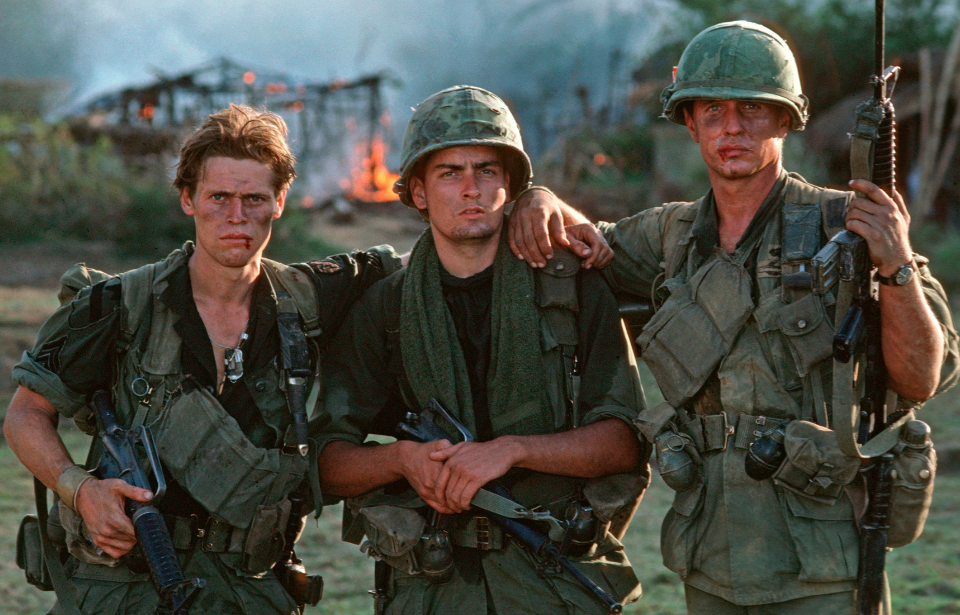 William Dafoe, Charlie Sheen and Tom Berenger standing together in costume