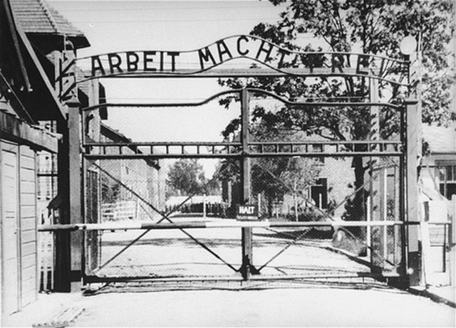 Black and white photograph of the gate at Auschwitz concentration camp in 1945