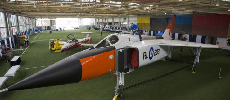 Volunteer dusting off a replica of the Avro Arrow