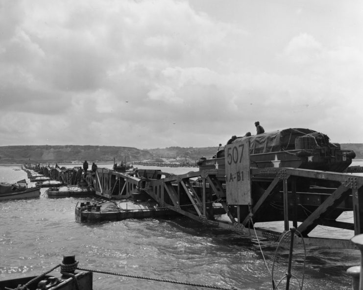 'Mulberry', the secret floating harbour being put to good use on Omaha beach in Normandy as a large truck drives over one of the pontoons.