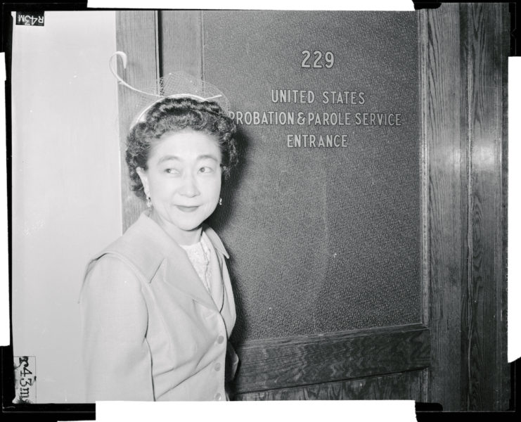 Iva Toguri D'Aquino standing at the entrance to the United States Probation & Parole Service