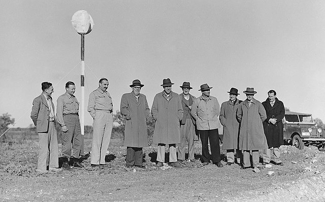 A black and white photograph of the Maralinga Committee visiting the test site