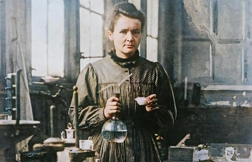 Marie Curie holding chemistry beakers