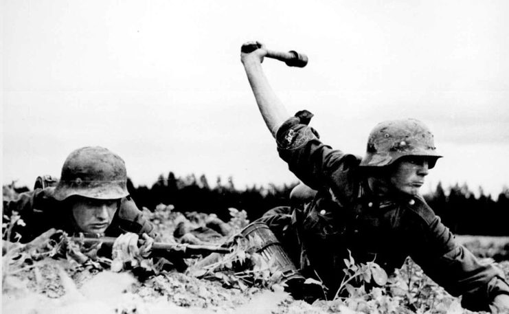 Soldier preparing to throw a grenade while another watches
