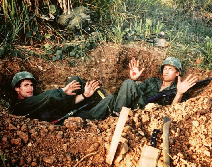 Willem Dafoe and Chris Pedersen lying in a crater while in costume