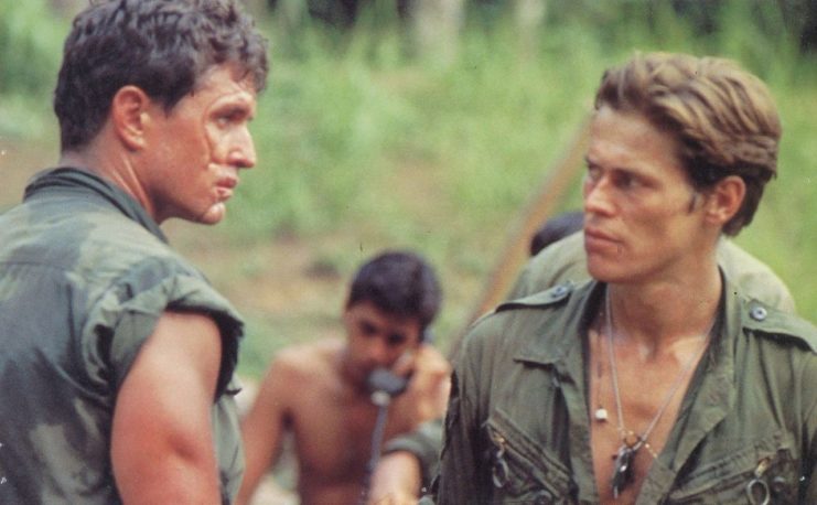 Tom Berenger and Willem Dafoe glare at each other in a scene from Platoon