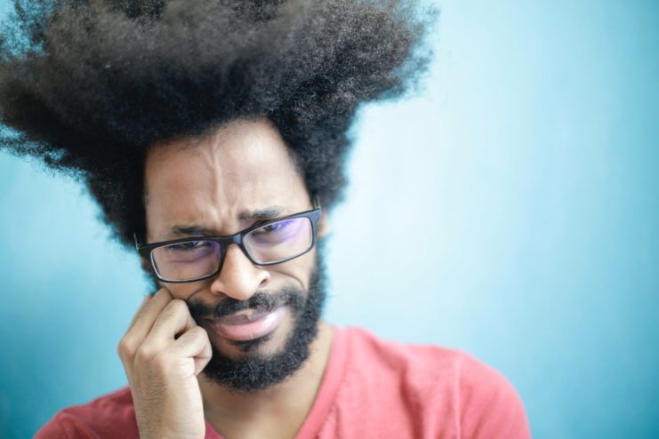 A skeptical man with his fist against his cheek