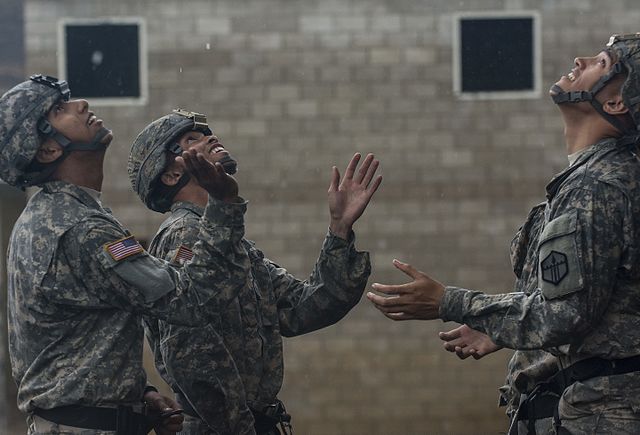 Three US Army soldiers standing in the rain