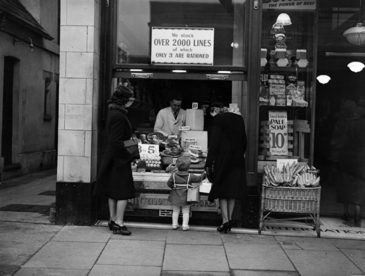 Two women and a child standing at a street-side merchant counter