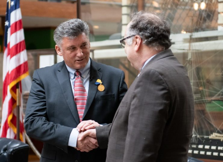 Tim Taylor of the Lost 52 Project receiving medal from Navy