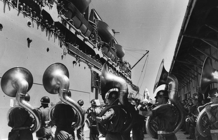 US Army band playing their instruments on a dock