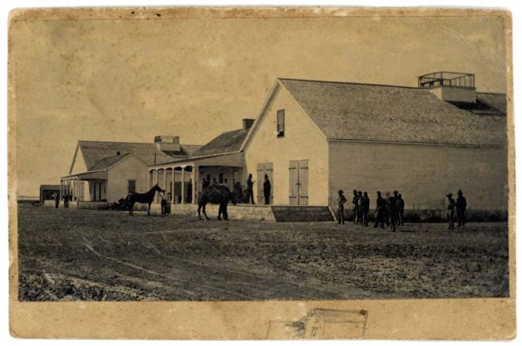 Only known surviving photo of the U.S. Camel Corps. A camel is tied up outside of what appears to be a frontier location. (Photo Credit: Rudolph D’Heureuse / Wikimedia Commons)