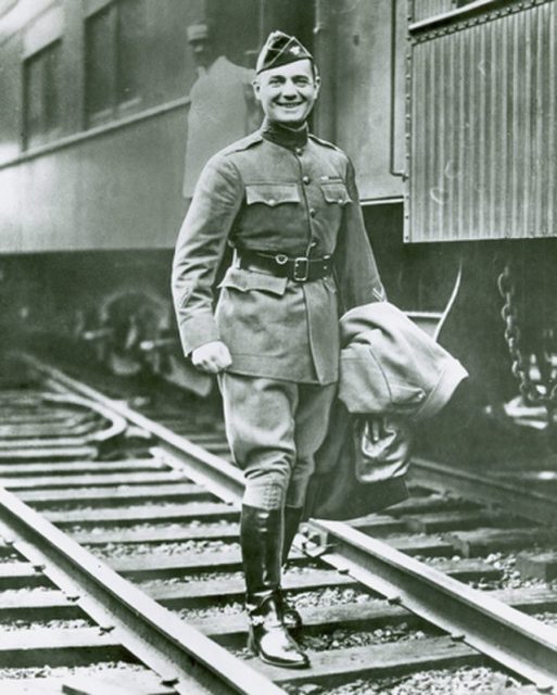 Bill Donovan walking along railway tracks in his military uniform