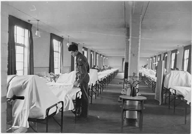 Solider surrounded by hospital beds