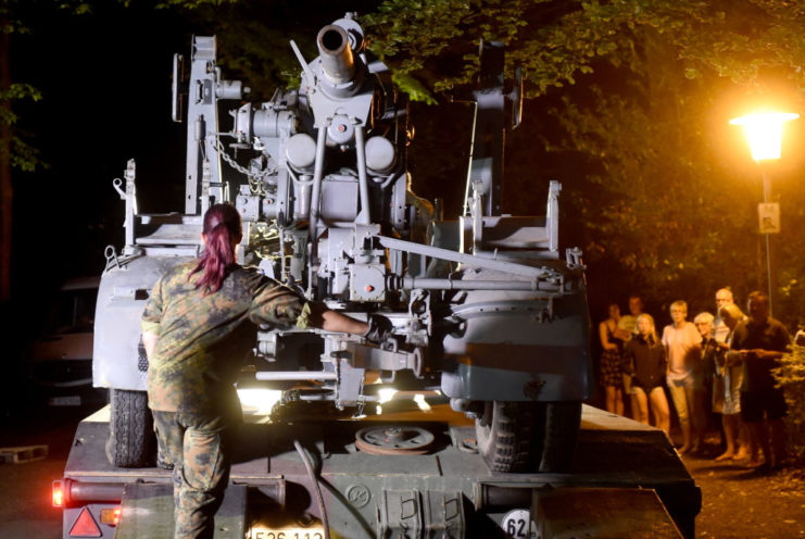 Female soldier loading the antiaircraft gun onto the truck