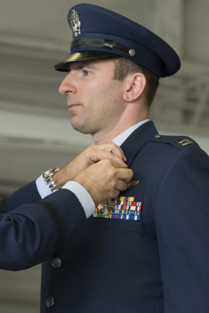 U.S. Air Force Capt. Jasen Hrisca, 73rd Expeditionary Special Operations Squadron Shadow 71 weapon systems, receives the Distinguished Flying Cross from U.S. Air Force Lt. Gen. Jim Slife, commander of Air Force Special Operations Command, during a ceremony at Hurlburt Field, Florida, June 22, 2021.