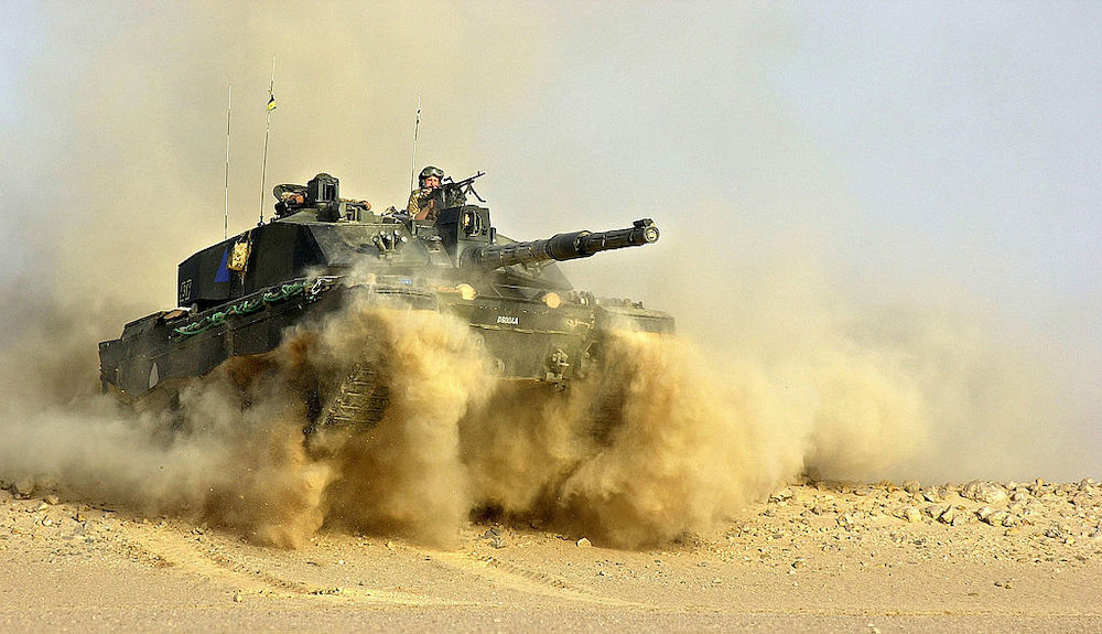 Soldier on top of a Challenger 2 tank in the desert