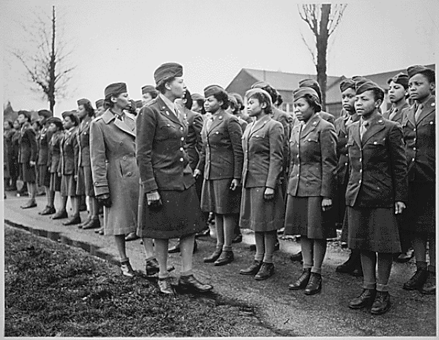 Charity Adams walking in front of a line of 6888th service women