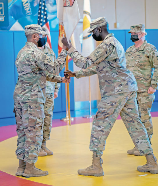 Capt. Robert K. Cheseret, center, commander, World Class Athlete Program (WCAP), passes the unit’s colors to 1st Sgt. Alex Ramos, first sergeant, WCAP, signifying his assumption of command during a change of command ceremony at Fort Carson May 14, 2021.