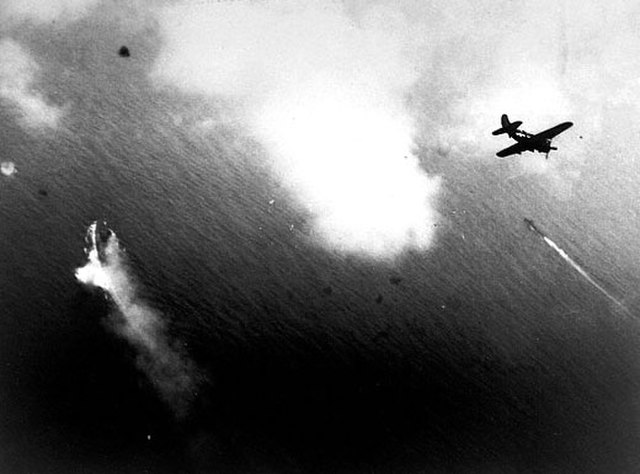 Curtiss SB2C Helldiver flying over the Yamato at sea