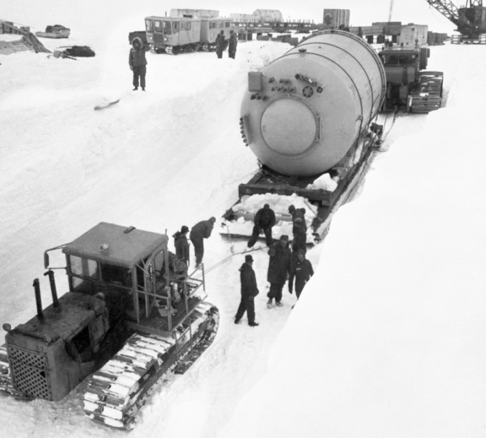 The U.S. Army Engineers who are installing a portable nuclear power plant shown as they move the vaper condenser, a component of plant, into the power plant.