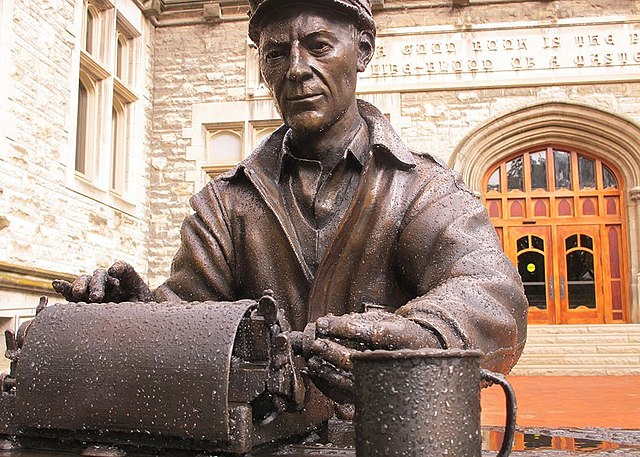 Statue of Ernie Pyle typing at a desk in front of Franklin Hall