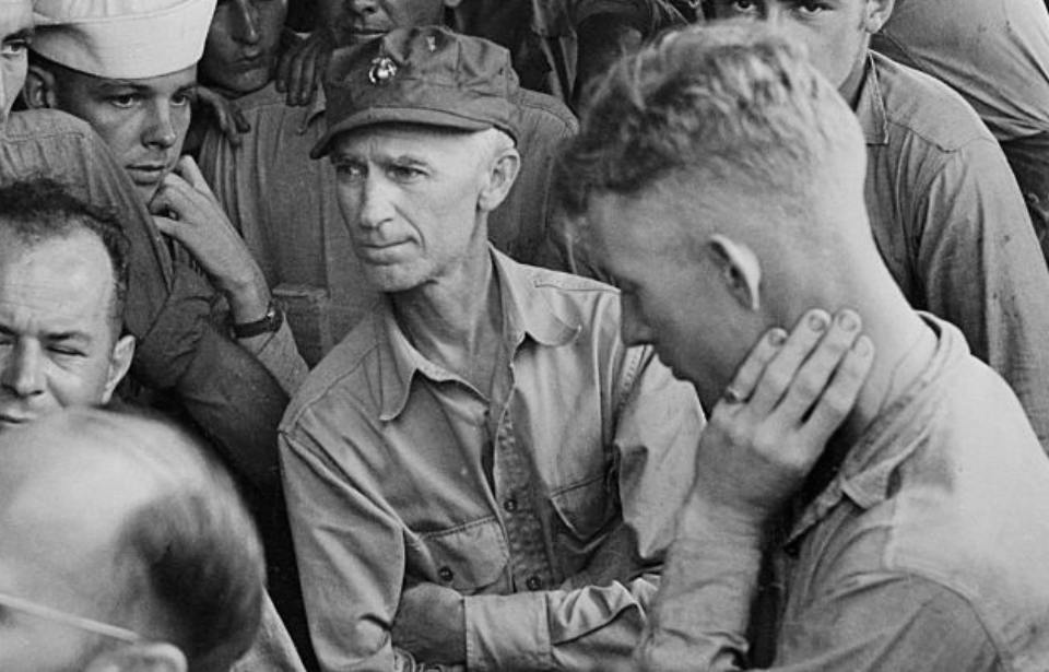 Ernie Pyle standing among a group of US servicemen