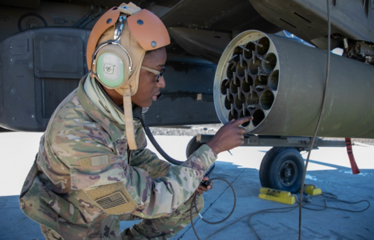 AH-64 Armament/Electrical/Avionic Systems Repairer (15Y) Soldiers of Delta 2-6 Cavalry Squadron, 25th Combat Aviation Brigade, 25th Infantry Division, work together to load rockets and 30mm cannon ammunition into the AH-64D Longbow Apache during aerial gunnery at Pōhakuloa Training Area, Hawaii. 