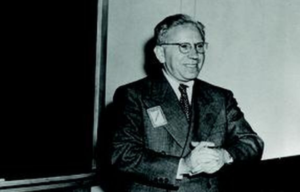 Abraham Wald standing beside a chalkboard.