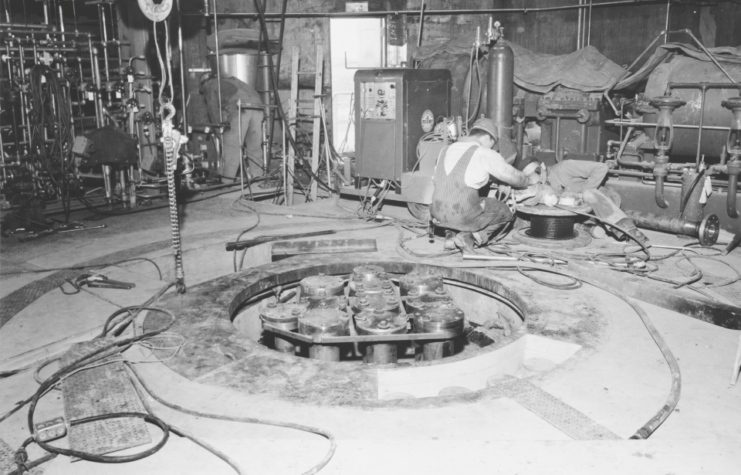 Interior view of SL-1 reactor building with reactor head in place in center foreground. March 21, 1958.