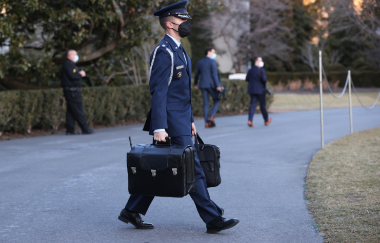 An Air Force aide carries the 'nuclear football' out of the White House as he accompanies U.S. President