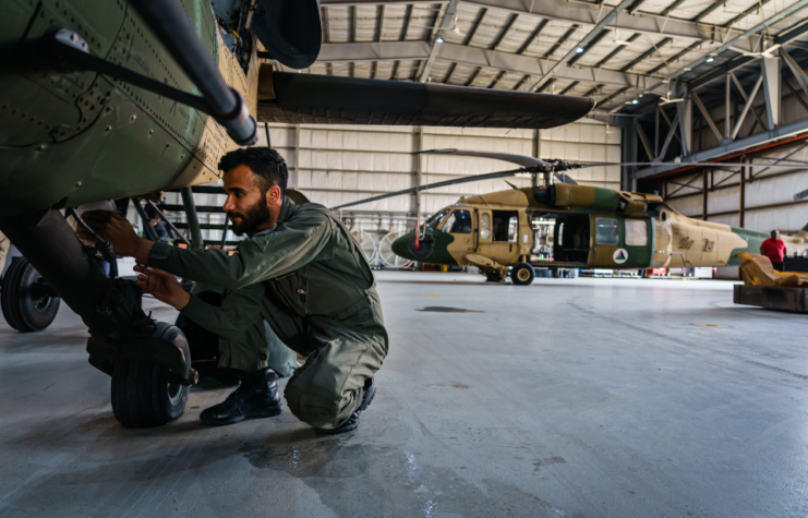 Afghan maintainers work on lubricating parts in an UH-60 Blackhawk at Kabul Airbase in Kabul, Afghanistan, Sunday, May 9, 2021.