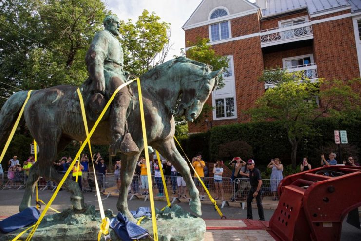 Robert E. Lee statue tied to a truck bed while people take pictures