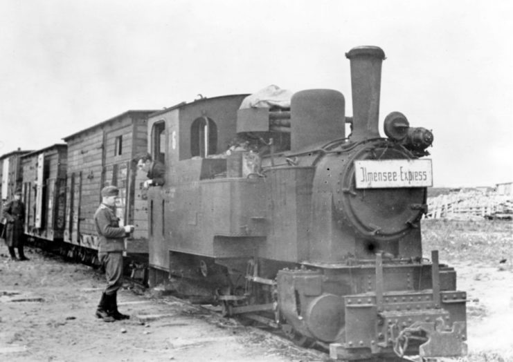 A Nazi soldier standing in front of the Ilmensee-Express train