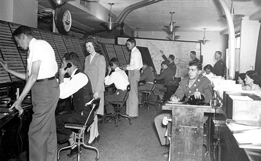 Men and women working in an air traffic control center