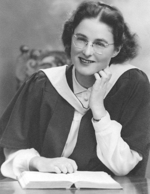 Alisa Maxwell sitting at a table with a book