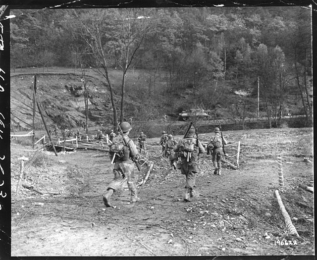 American infantrymen walking beside a stream