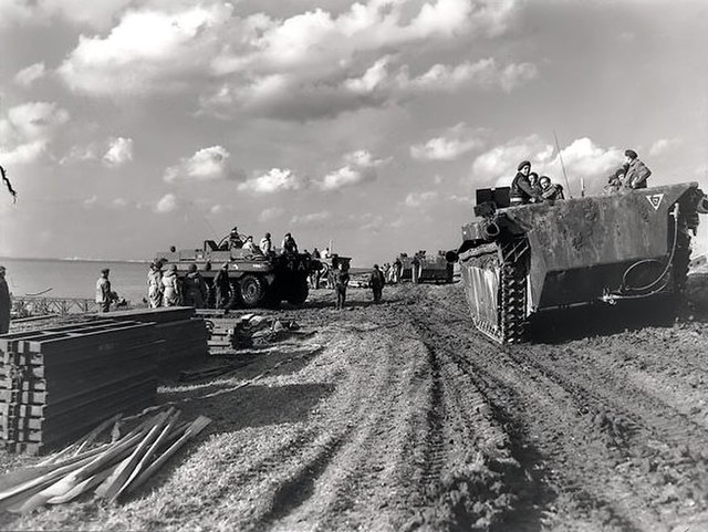 Tanks and soldiers on a dirt roadway