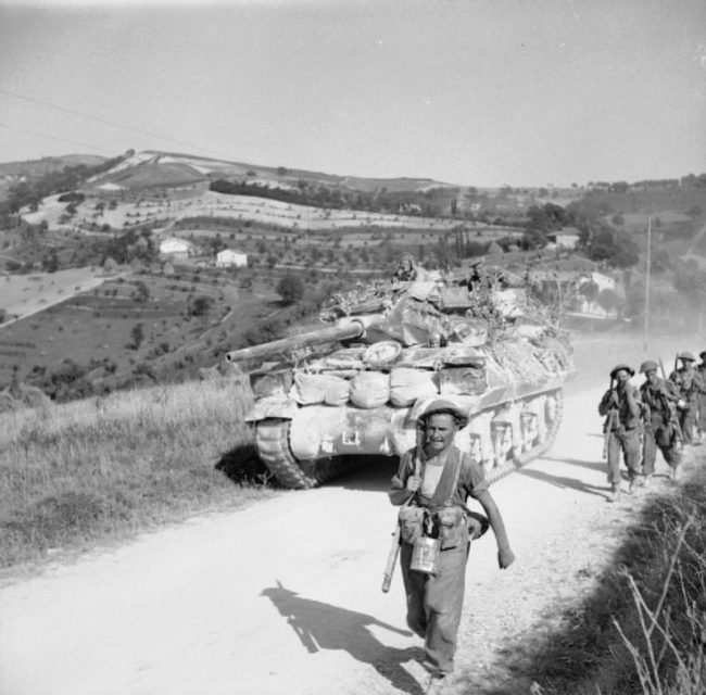 British soldiers walking beside a tank along the Gothic Line