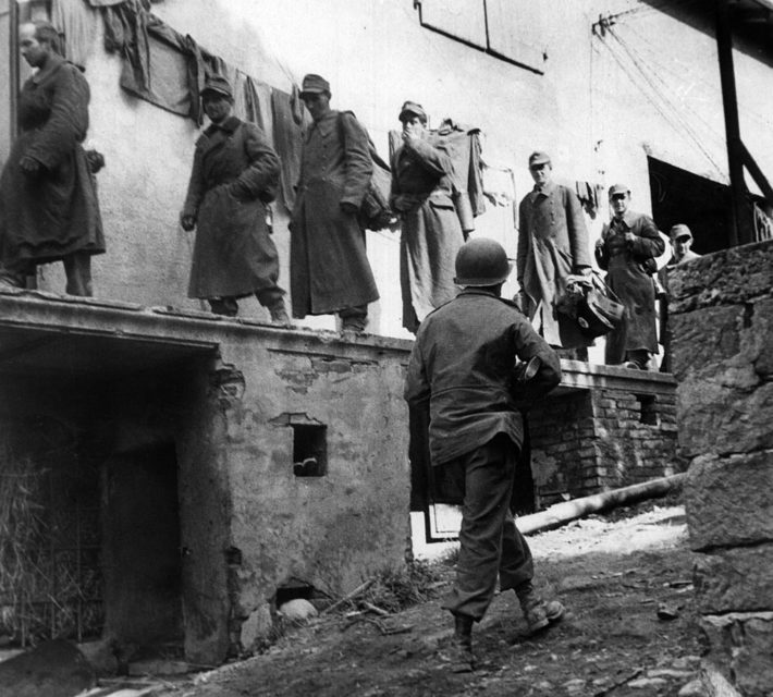 German soldiers walking alongside a building