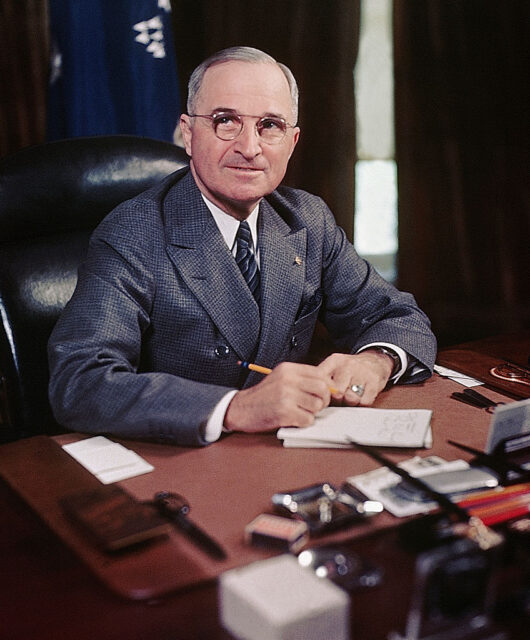 Harry Truman sitting at his desk