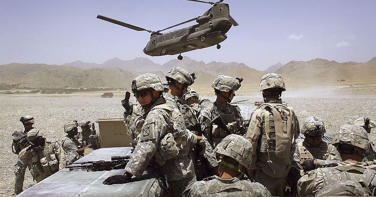 U.S. soldiers gathered below an army helicopter