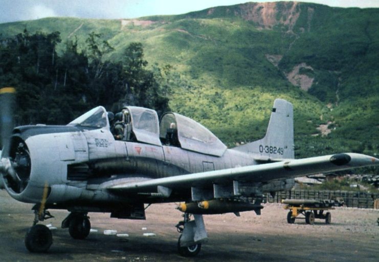 A Royal Lao Air Force (RLAF) North American T-28D-5 Trojan armed trainer loaded with bombs at Long Tieng airfield in Laos, September 1972 (Photo Credit: Hugh Tovar – Kenneth Conboy, War in Laos 1954-1975, Squadron/Signal Publications, 1994 – Public Domain).