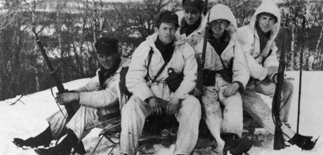 Five Norwegian soldiers sitting together in the snow