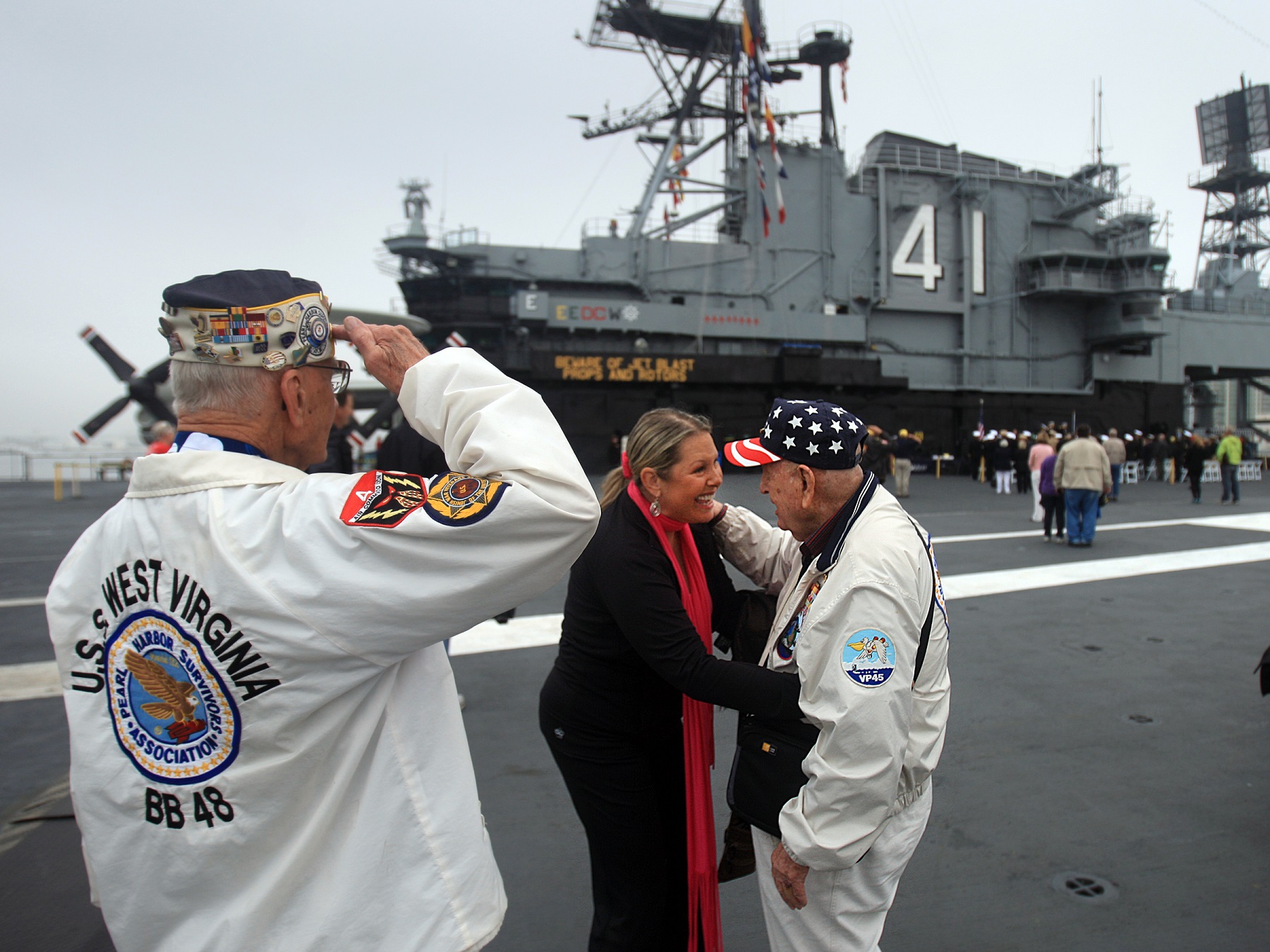 Pearl Harbor survivors Stu Hedley, 91, left, salutes, as Doyle McKee is thanked for his service by Rebecca Shaffner during the annual Pearl Harbor Day Remembrance Ceremony aboard the USS Midway Museum's Flight Deck in San Diego, Friday Dec. 7, 2012. (Photo by Allen J. Schaben/Los Angeles Times via Getty Images)