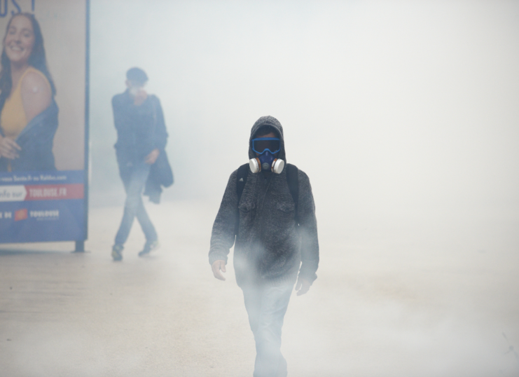 protestor walking through tear gas