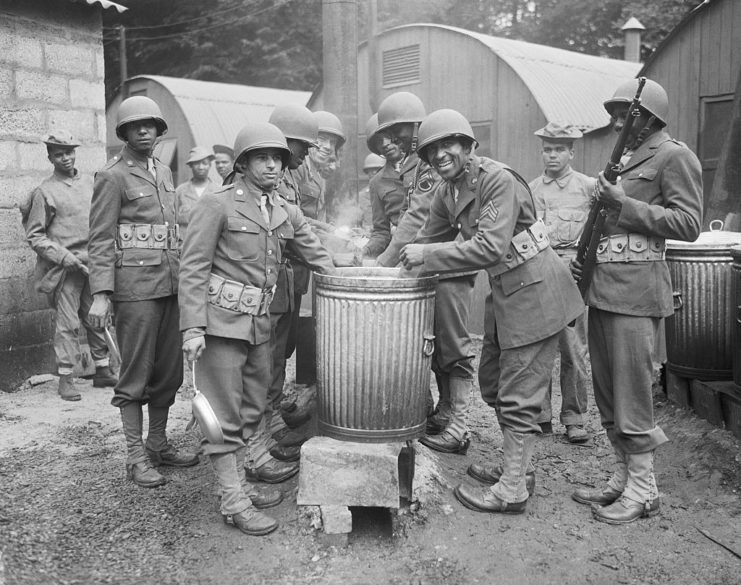 American troops surrounding a steaming barrel