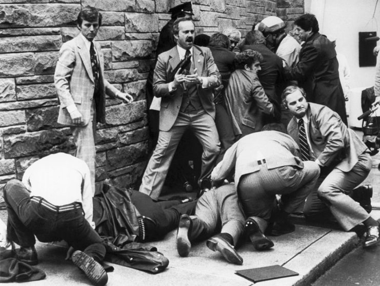 Secret Service agents and police officers crowded in front of a brick wall