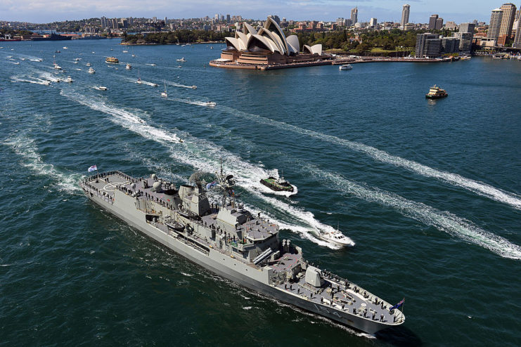 Warship at sea, surrounded by smaller boats