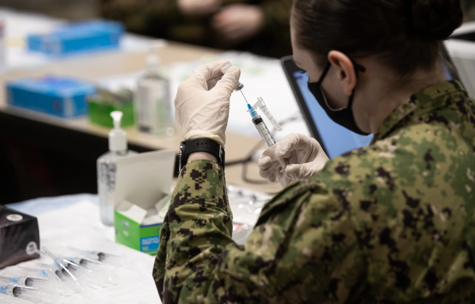 Female soldier holding a COVID-19 vaccination